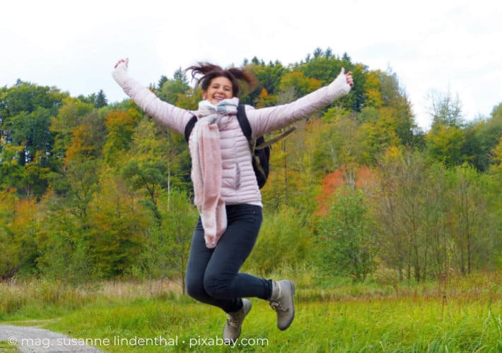 Wechseljahre Frau springt vor Freude in die Luft